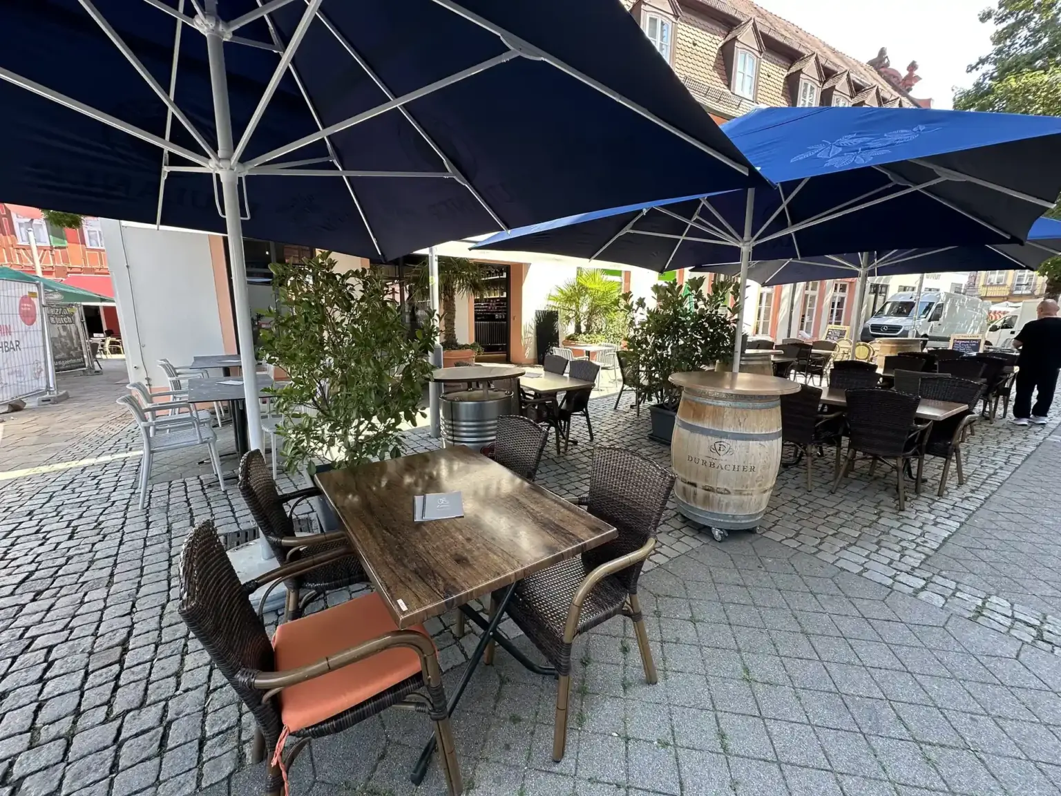 Terrasse mit Rattanstühlen und Weinfass „Durbacher“ als Stehtisch auf dem Marktplatz